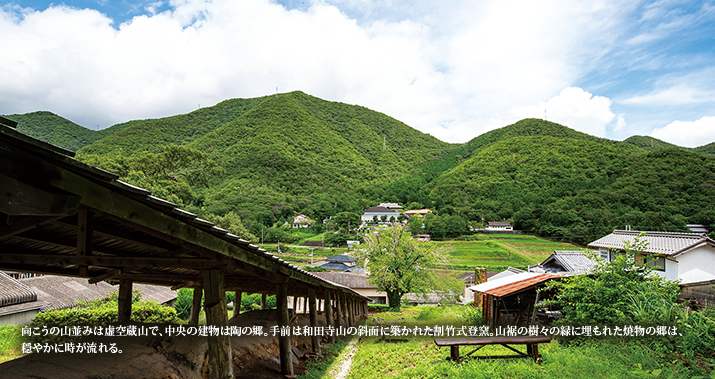 向こうの山並みは虚空蔵山で、中央の建物は陶の郷。手前は和田寺山の斜面に築かれた割竹式登窯。山裾の樹々の緑に埋もれた焼物の郷は、穏やかに時が流れる。