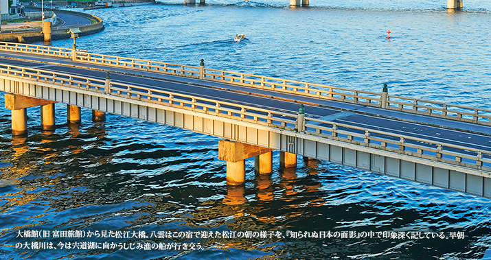 大橋館(旧 富田旅館)から見た松江大橋。八雲はこの宿で迎えた松江の朝の様子を、『知られぬ日本の面影』の中で印象深く記している。早朝の大橋川は、今は宍道湖に向かうしじみ漁の船が行き交う。